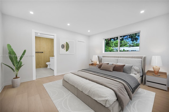 bedroom featuring connected bathroom and light wood-type flooring