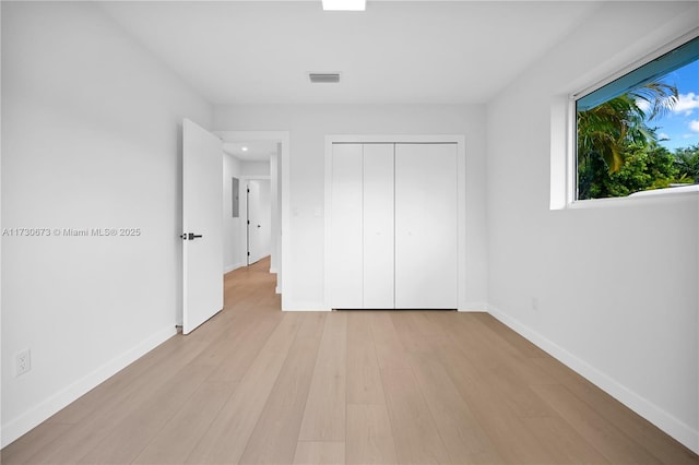 unfurnished bedroom with a closet and light wood-type flooring