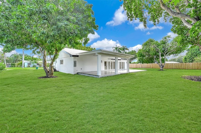 rear view of property featuring a yard and a patio