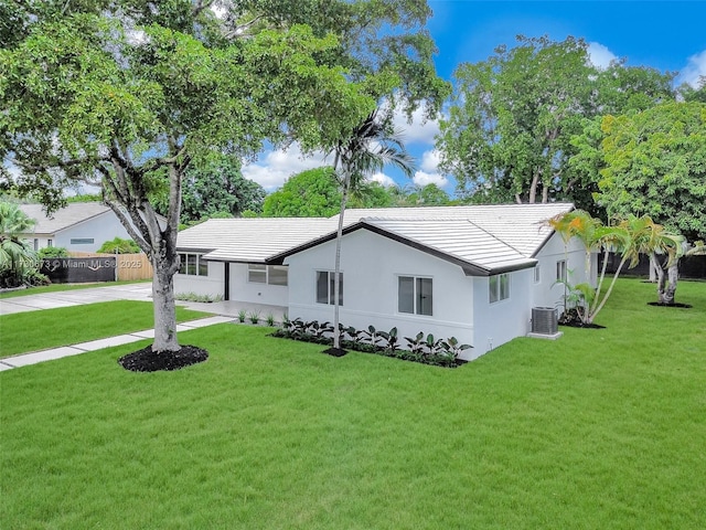 view of front of property with central AC and a front yard