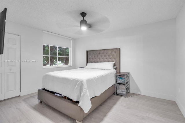 bedroom featuring a textured ceiling, light hardwood / wood-style flooring, and ceiling fan