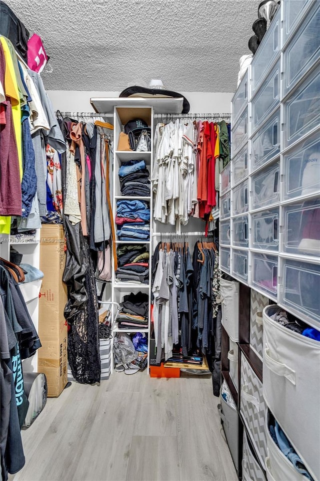 walk in closet with wood finished floors