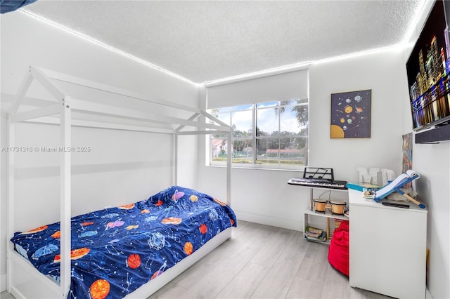 bedroom featuring a textured ceiling and wood finished floors