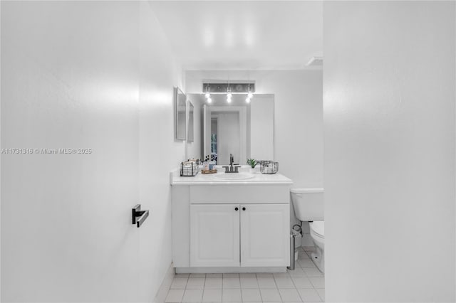 bathroom with tile patterned flooring, baseboards, vanity, and toilet