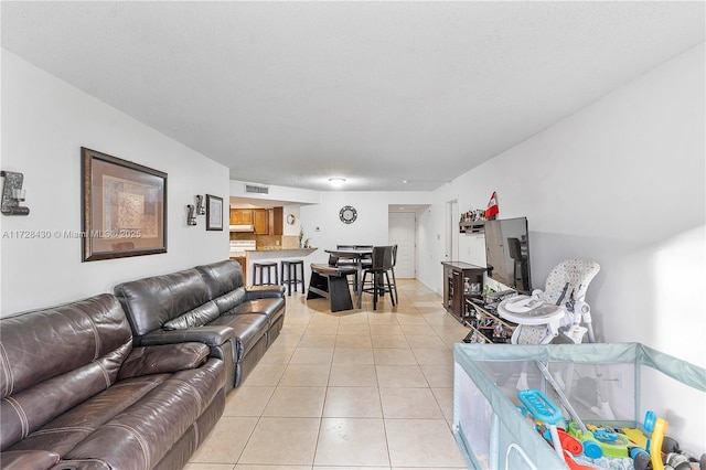 living room with a textured ceiling and light tile patterned floors