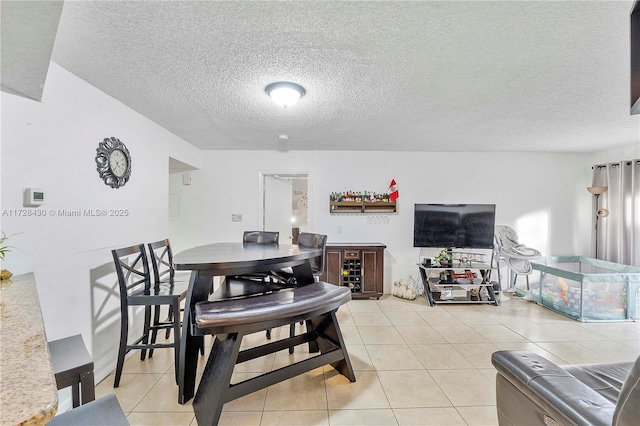 dining area with light tile patterned floors and a textured ceiling