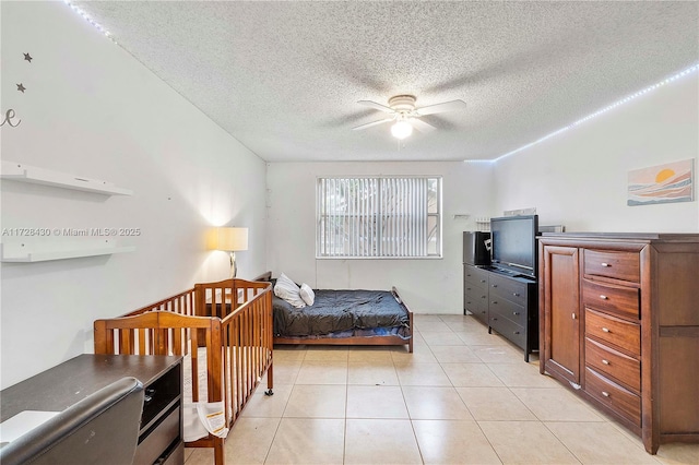 bedroom featuring light tile patterned floors, a textured ceiling, and ceiling fan