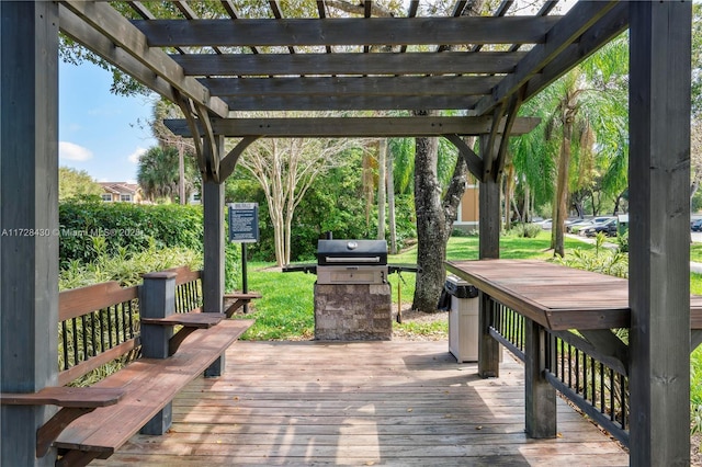 wooden deck with a grill, a yard, and a pergola