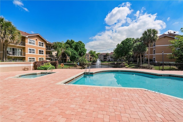 view of swimming pool featuring a hot tub