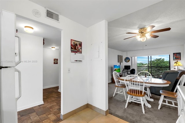 dining space with ceiling fan and a textured ceiling