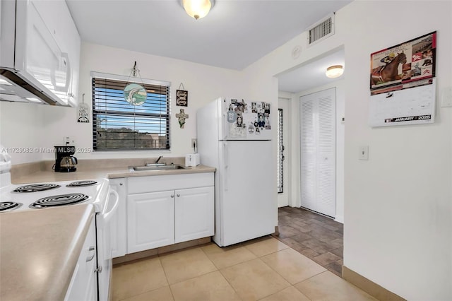 kitchen featuring sink, white appliances, white cabinets, and light tile patterned flooring