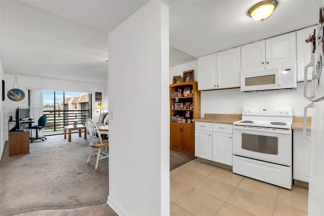 kitchen featuring white appliances, light colored carpet, and white cabinets