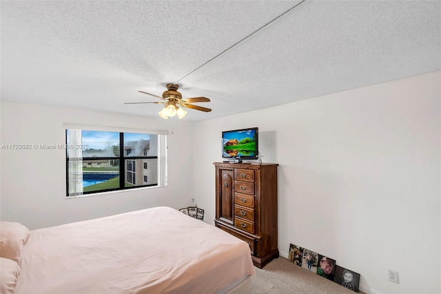 bedroom with carpet floors, a textured ceiling, and ceiling fan