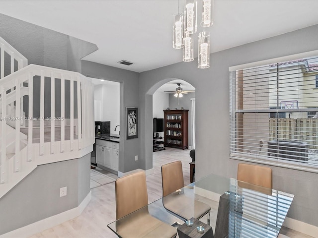 dining area featuring sink, ceiling fan, and light wood-type flooring