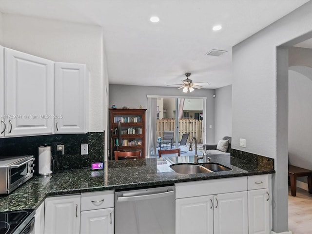 kitchen featuring tasteful backsplash, white cabinetry, sink, stainless steel dishwasher, and kitchen peninsula