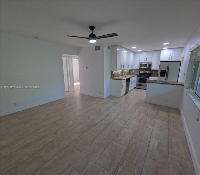 kitchen with tasteful backsplash, ceiling fan, white cabinets, and appliances with stainless steel finishes