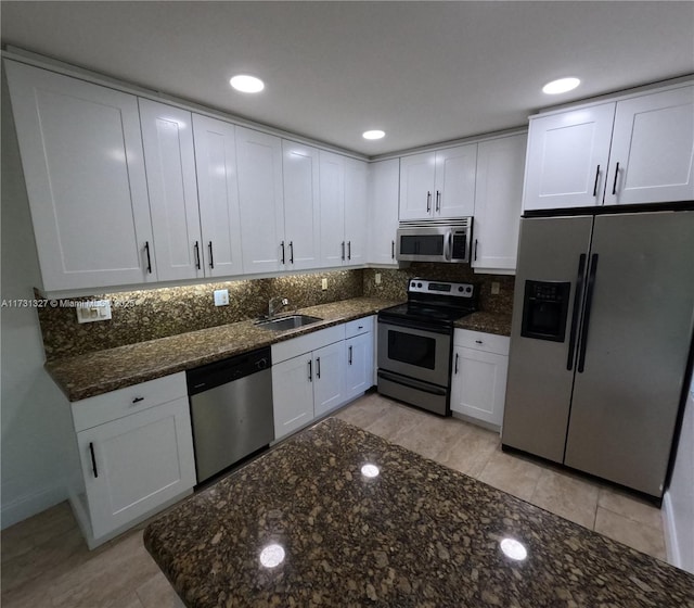 kitchen featuring backsplash, appliances with stainless steel finishes, sink, and white cabinets