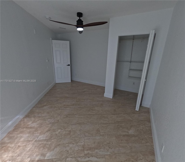 unfurnished bedroom with ceiling fan and a closet