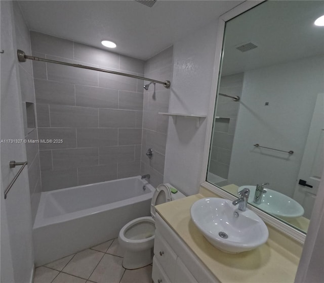 full bathroom featuring vanity, tiled shower / bath, tile patterned floors, and toilet