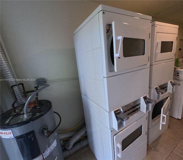 utility room with water heater and stacked washer and clothes dryer