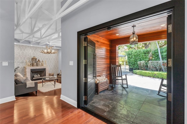 491 SW 22nd Rd, Miami, FL 33129 - doorway with baseboards, wallpapered walls, an accent wall, a chandelier, and a fireplace