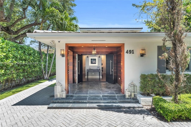 doorway to property featuring stucco siding