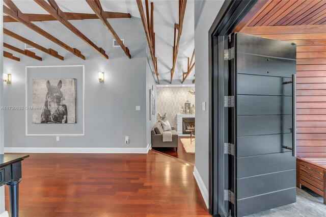 living room featuring lofted ceiling with beams, dark wood-type flooring, and a chandelier