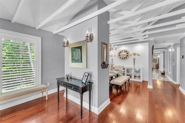 hall with an inviting chandelier, baseboards, and wood finished floors