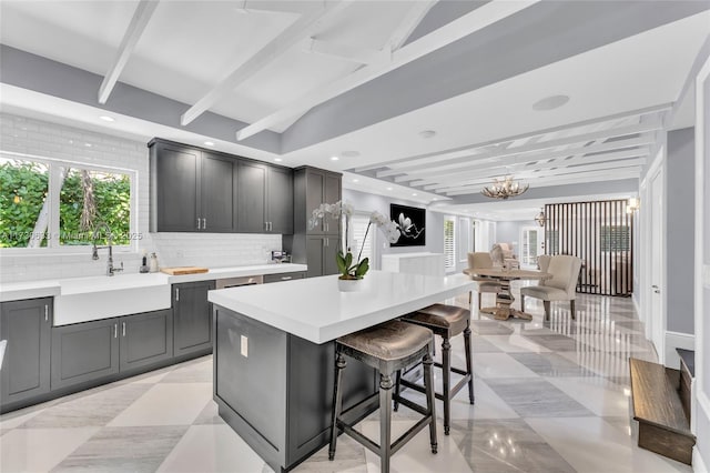 kitchen featuring light countertops, plenty of natural light, a kitchen island, and tasteful backsplash