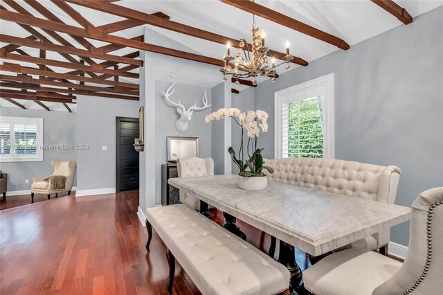 kitchen with beamed ceiling, sink, a breakfast bar area, and wall chimney exhaust hood