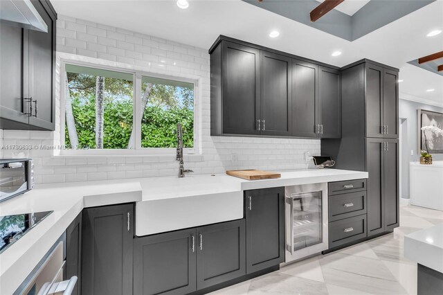 kitchen featuring sink, black electric stovetop, wine cooler, and decorative backsplash