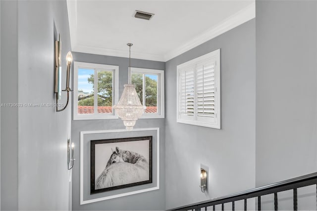 interior details with crown molding, a notable chandelier, and visible vents