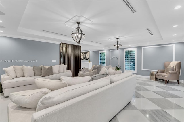 living room featuring a tray ceiling and a notable chandelier