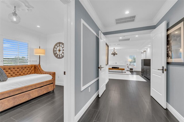 hallway with an inviting chandelier, ornamental molding, and dark hardwood / wood-style floors