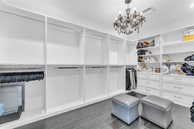 spacious closet with a chandelier and visible vents