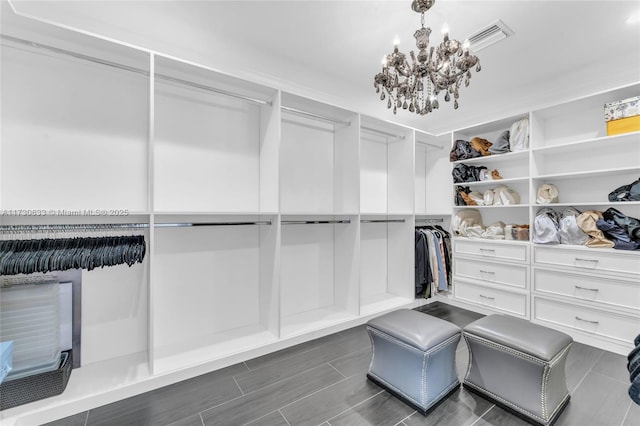 spacious closet featuring a chandelier, wood finish floors, and visible vents