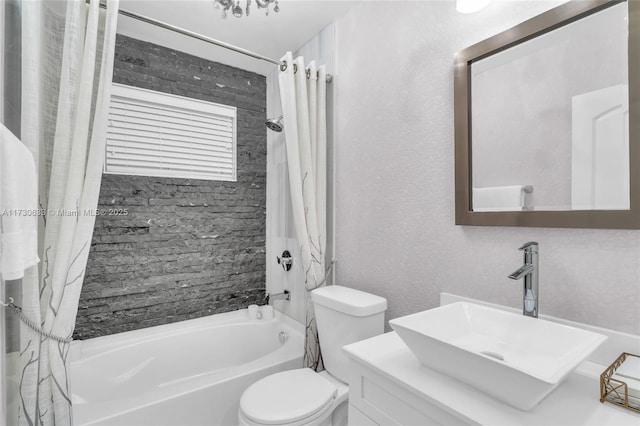 bathroom featuring a textured wall, vanity, shower / bath combo with shower curtain, and toilet