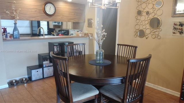 tiled dining area featuring a chandelier and sink