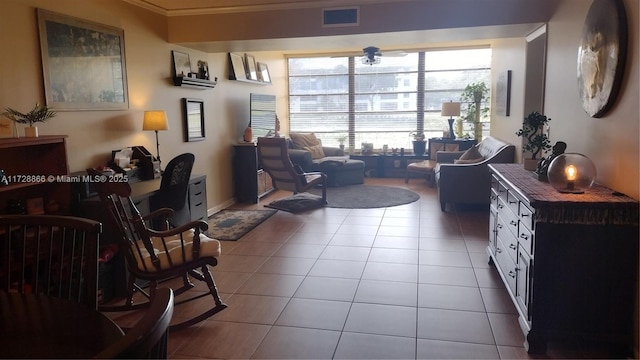 living area featuring ornamental molding and light tile patterned floors