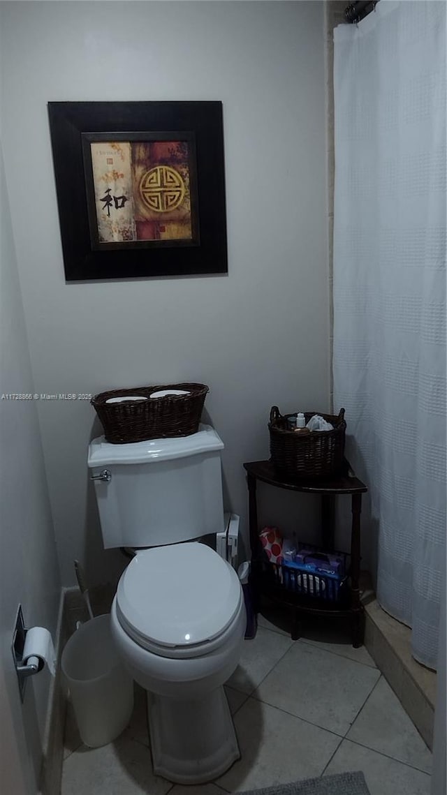 bathroom with walk in shower, tile patterned floors, and toilet