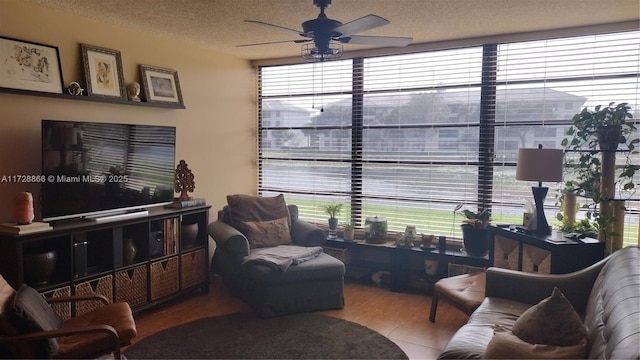 living room with ceiling fan and a textured ceiling