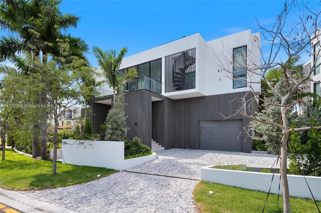 291 Palm Ave, Miami Beach, FL 33139 - contemporary home with a garage, a balcony, decorative driveway, and a front yard