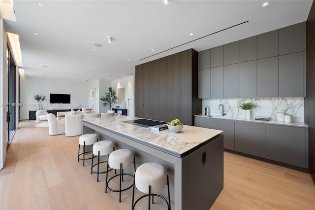 291 Palm Ave, Miami Beach, FL 33139 - kitchen featuring light wood-style flooring, gray cabinets, modern cabinets, a kitchen island, and a kitchen breakfast bar