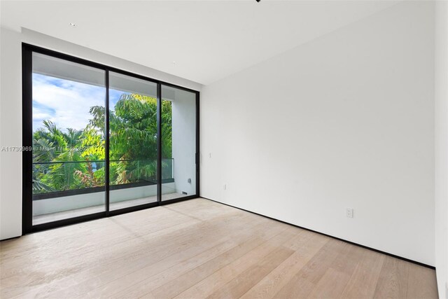 unfurnished room featuring expansive windows and light wood-type flooring