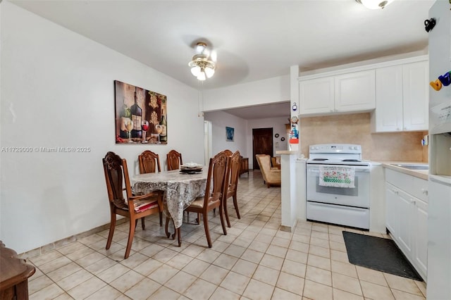 kitchen with light tile patterned floors, white electric range, white cabinets, and ceiling fan