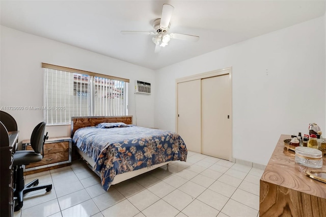 tiled bedroom with an AC wall unit, ceiling fan, and a closet