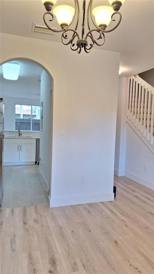 unfurnished dining area featuring sink and light hardwood / wood-style floors