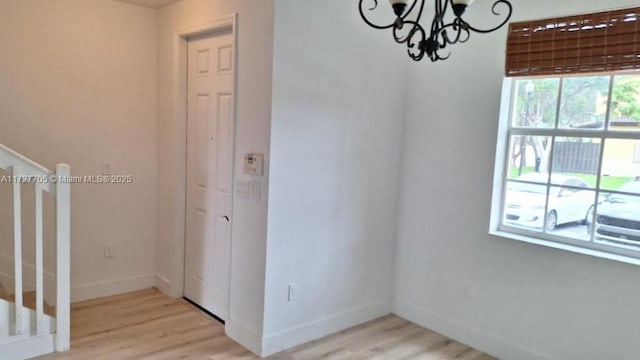 interior space with a notable chandelier and light wood-type flooring