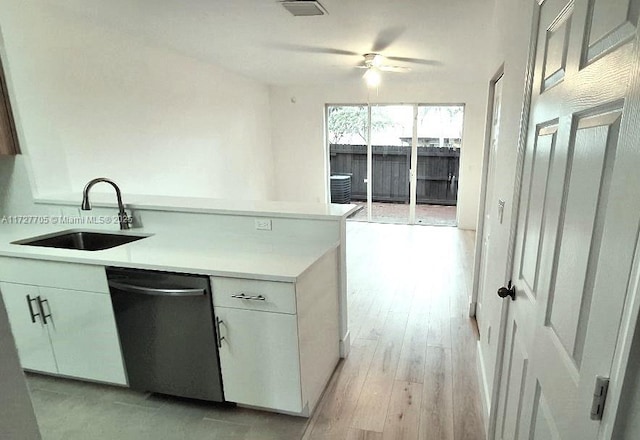 kitchen featuring white cabinetry, sink, dishwashing machine, ceiling fan, and light hardwood / wood-style flooring