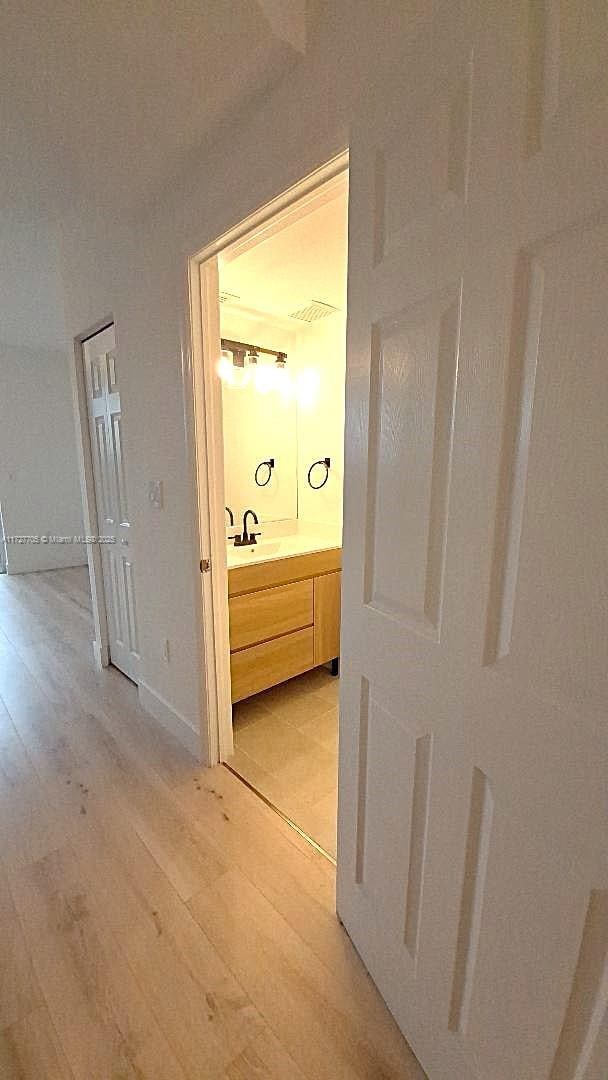 hallway featuring sink and light hardwood / wood-style flooring